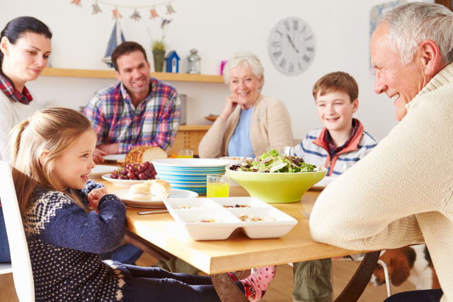 Multi Generation Family Eating Lunch At Kitchen Table